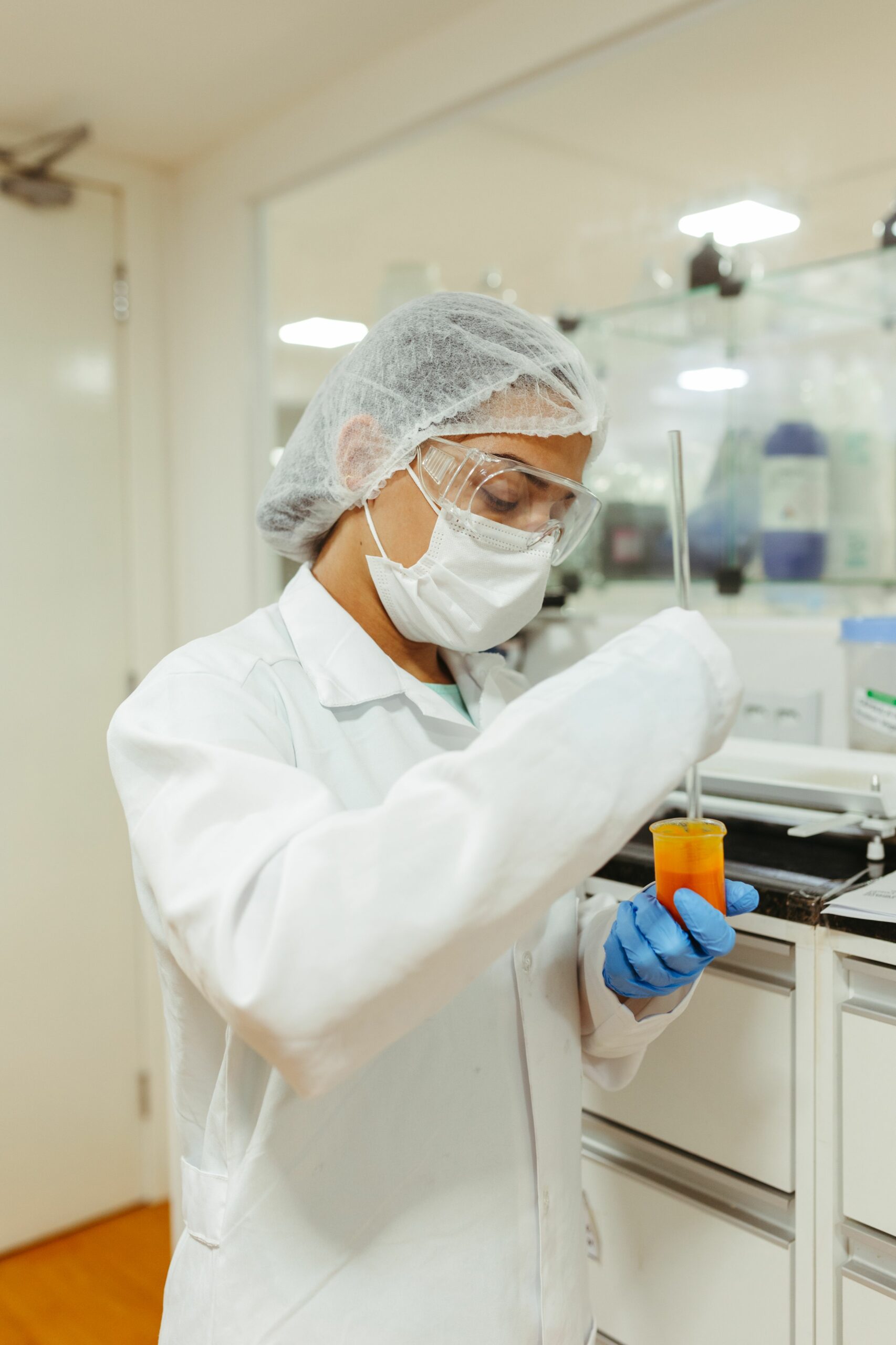 Trabajador con indumentaria de seguridad alimentaria realizando control de calidad en planta de fabricación certificada