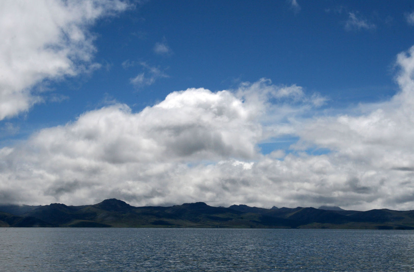 Lago Junín o Chinchaycocha, en la meseta de Junín, con cerros al fondo y cielo con nubes