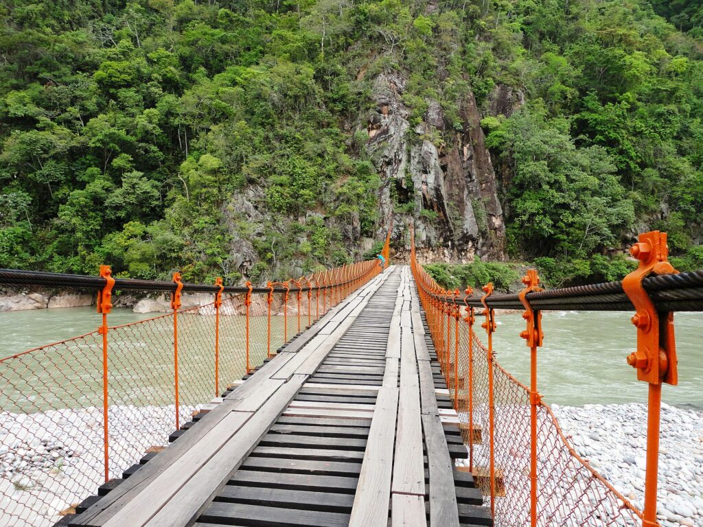 Puente colgante Kimiri sobre el río, rodeado de vegetación de selva, en La Merced (Chanchamayo)